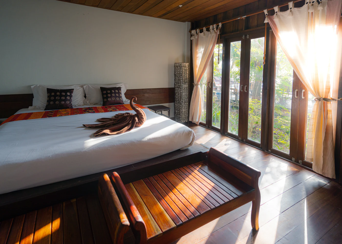 Uvendra Signature Suite bedroom with tall windows and timber floors