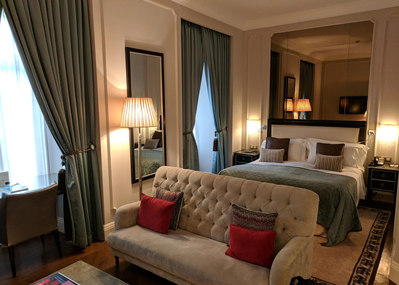 Uvendra guest room interior with a made bed and warm bedside lighting